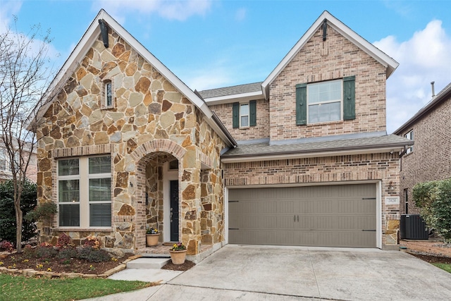 view of front of house featuring a garage and central AC