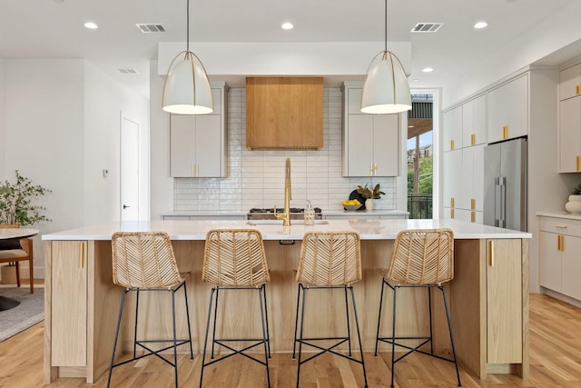 4330 Dickason Ave Unit 201, Dallas, TX 75219 - kitchen featuring backsplash, light wood-style flooring, light countertops, a sink, and recessed lighting
