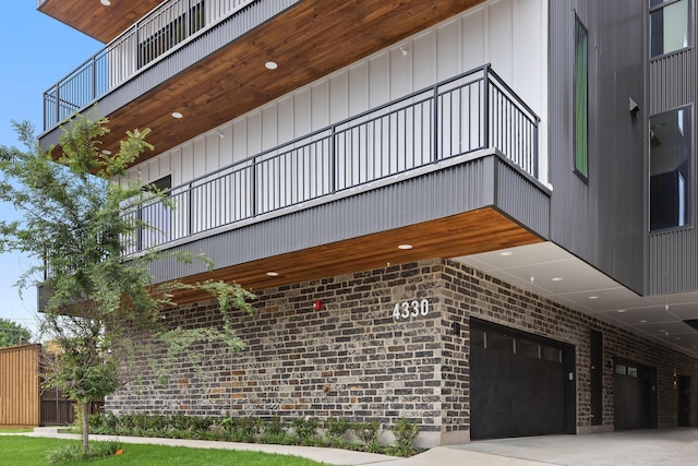 4330 Dickason Ave Unit 201, Dallas, TX 75219 - view of side of home featuring a garage, a balcony, and brick siding