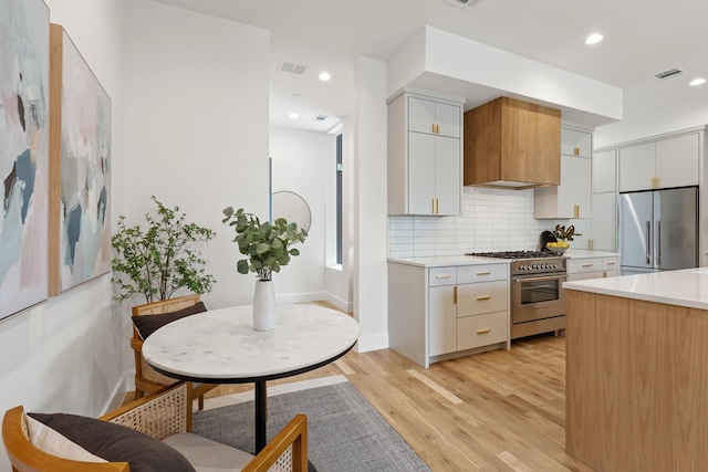 4330 Dickason Ave Unit 201, Dallas, TX 75219 - kitchen with premium appliances, light countertops, light wood finished floors, tasteful backsplash, and recessed lighting