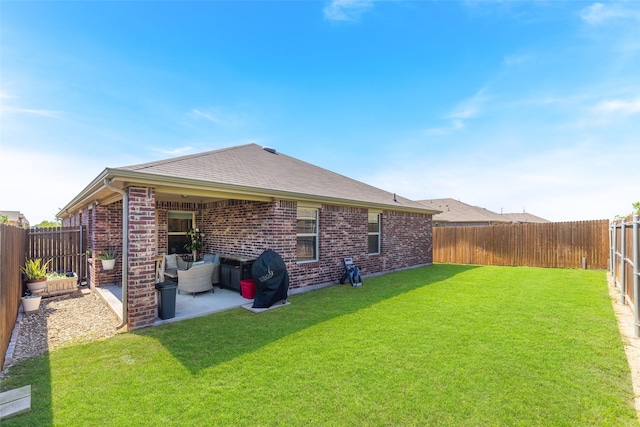 back of house with a patio area and a lawn