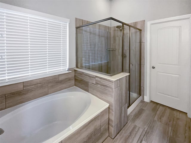 bathroom featuring shower with separate bathtub