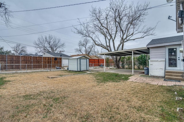 view of yard featuring a storage shed, a carport, and a patio