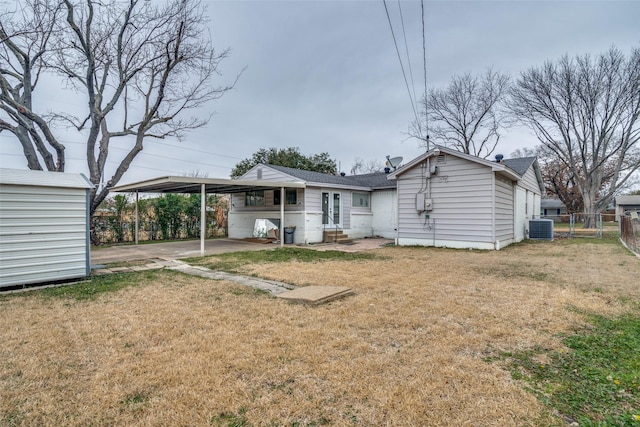 back of house with a carport, a yard, and central air condition unit