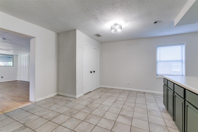 spare room featuring light tile patterned floors and a textured ceiling