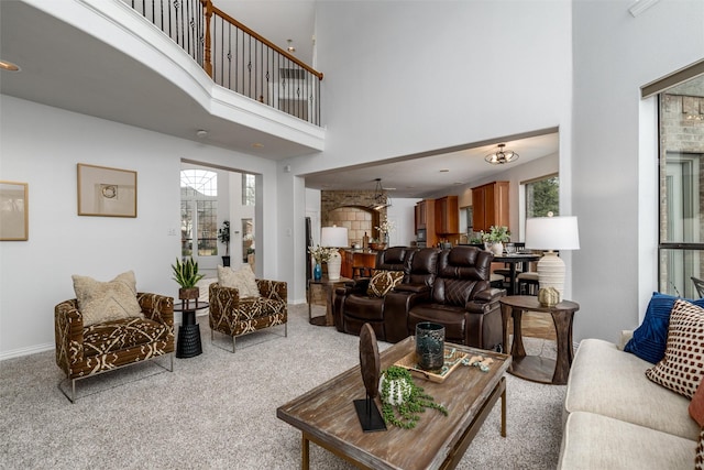 carpeted living room featuring a towering ceiling