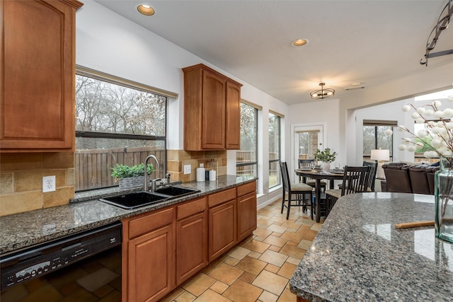 kitchen with tasteful backsplash, dark stone counters, dishwasher, and sink