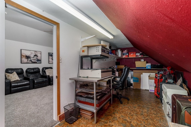 carpeted home office featuring vaulted ceiling and a textured ceiling