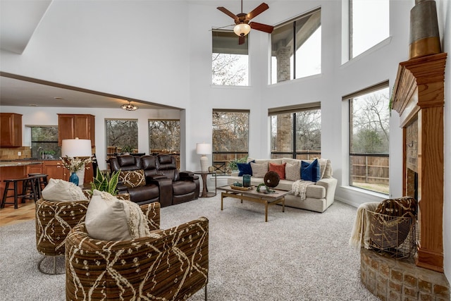 living room with sink, light colored carpet, and ceiling fan