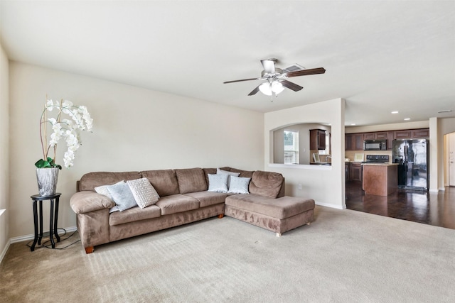 living room with light colored carpet and ceiling fan