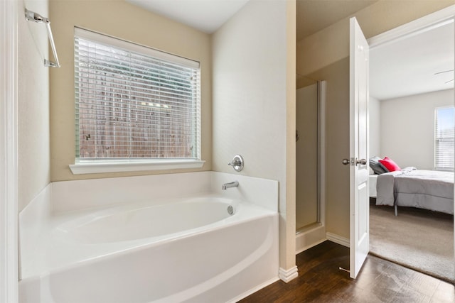 bathroom featuring wood-type flooring and shower with separate bathtub