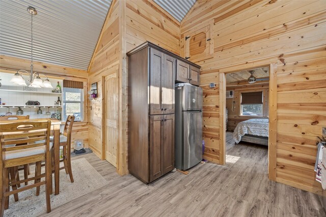 full bathroom featuring hardwood / wood-style floors, wooden walls, shower / bath combination with curtain, vaulted ceiling, and toilet