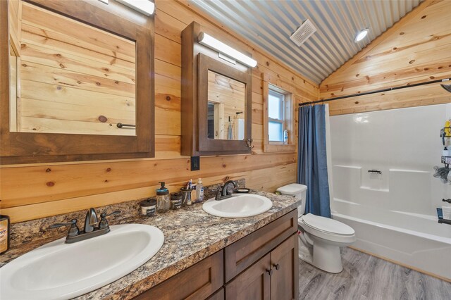 kitchen featuring sink, wood walls, light hardwood / wood-style flooring, appliances with stainless steel finishes, and stone counters