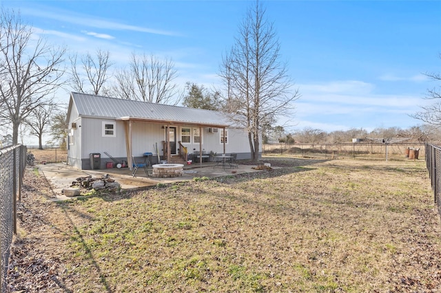 rear view of house featuring an outdoor fire pit, a yard, and a patio