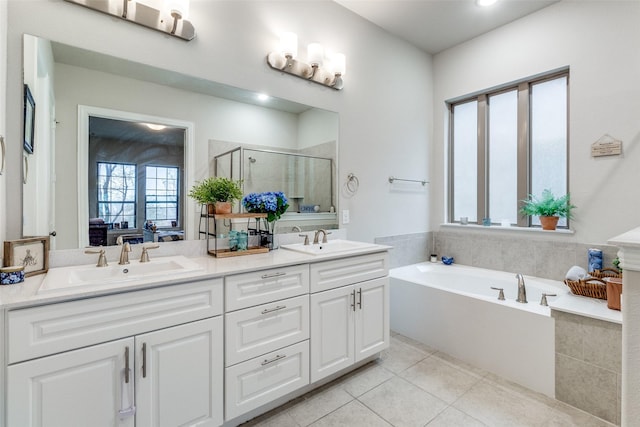 bathroom with tile patterned floors, shower with separate bathtub, and vanity