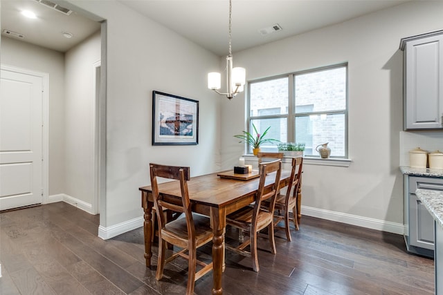 dining space with dark hardwood / wood-style flooring and a notable chandelier