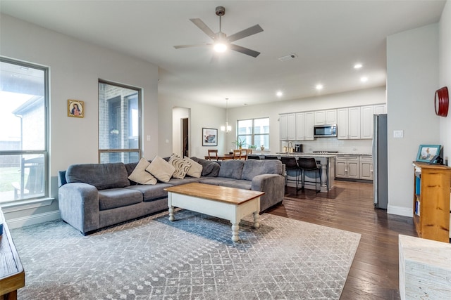 living room with dark hardwood / wood-style flooring and ceiling fan