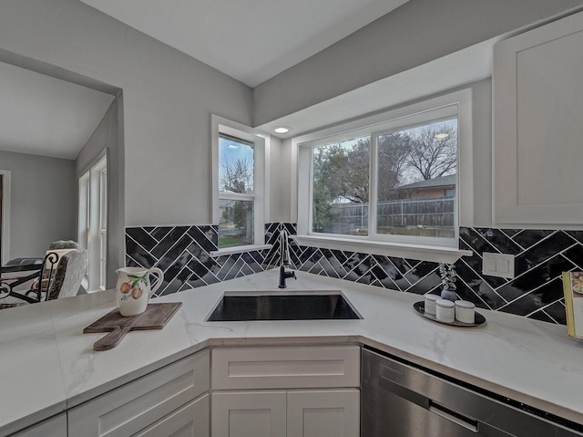 kitchen with sink, dishwasher, and white cabinets