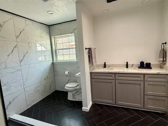 bathroom featuring vanity, a textured ceiling, and toilet