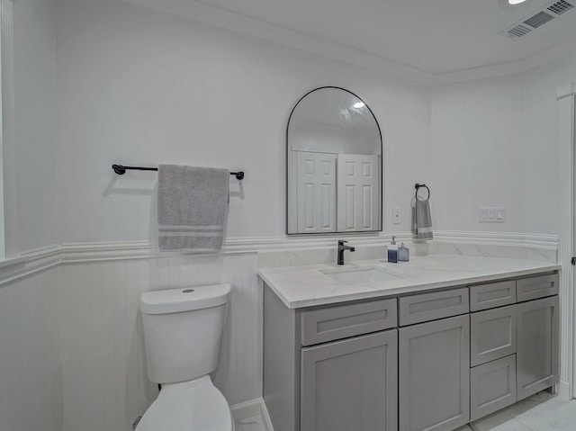 bathroom with vanity, crown molding, and toilet