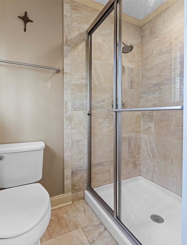 bathroom with a shower with door and toilet