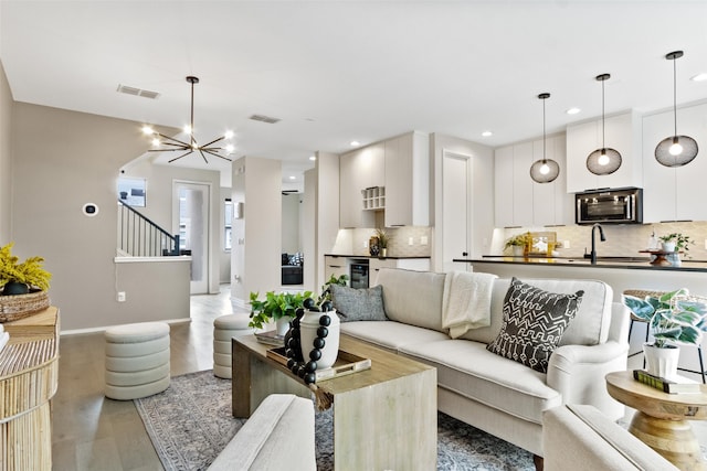 living room with hardwood / wood-style flooring, a chandelier, and sink