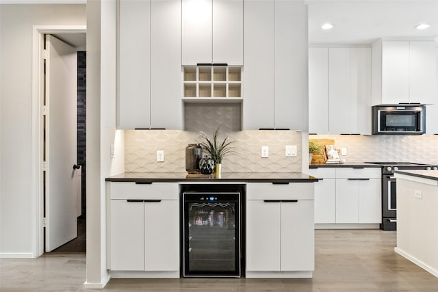 kitchen featuring white cabinetry, backsplash, stainless steel appliances, beverage cooler, and light wood-type flooring