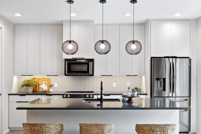 kitchen featuring hanging light fixtures, white cabinetry, sink, and stainless steel fridge with ice dispenser