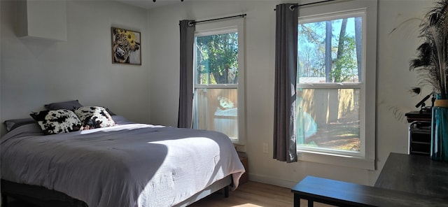 bedroom featuring multiple windows and light wood-type flooring