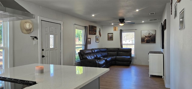 living room featuring dark wood-type flooring and ceiling fan