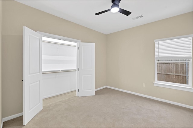 unfurnished bedroom featuring light colored carpet, ceiling fan, and a closet