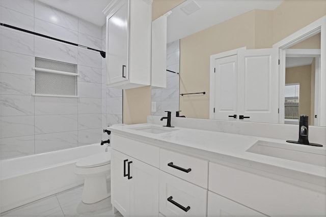 full bathroom featuring vanity, tiled shower / bath, and toilet