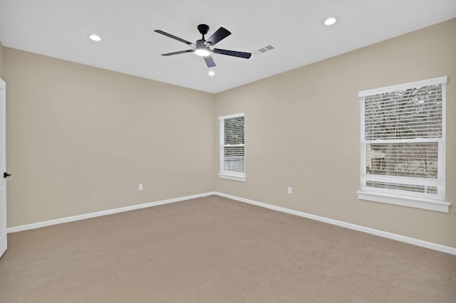 carpeted spare room featuring ceiling fan