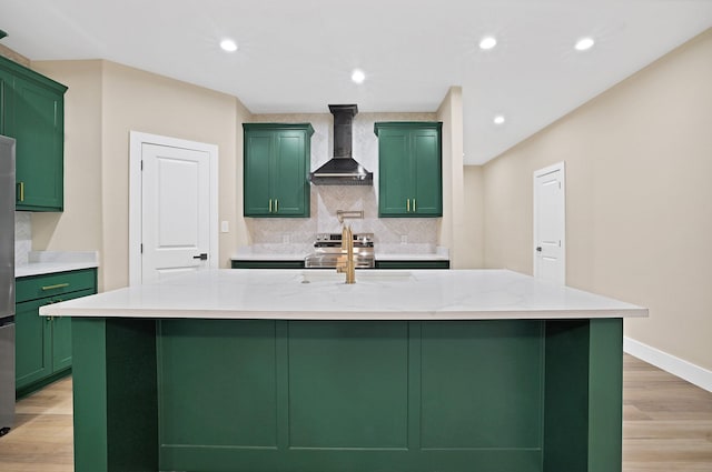 kitchen with a large island, light stone countertops, and wall chimney range hood