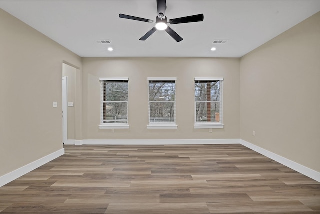 spare room with ceiling fan and light wood-type flooring