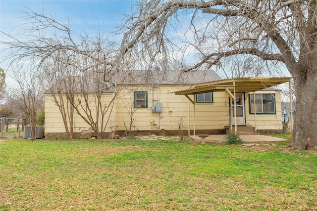 back of property with a yard and a patio area