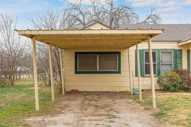 view of side of home featuring a carport and a yard