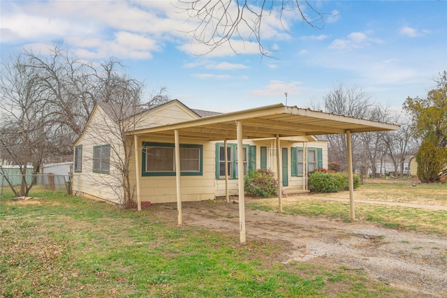 view of front of house featuring a carport and a front lawn