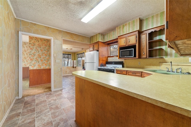 kitchen with built in microwave, sink, a textured ceiling, range with electric stovetop, and white refrigerator