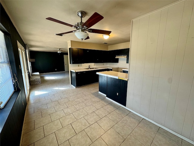 kitchen with light tile patterned flooring, sink, and ceiling fan