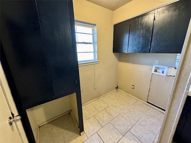 washroom featuring washer hookup, cabinets, and light tile patterned flooring