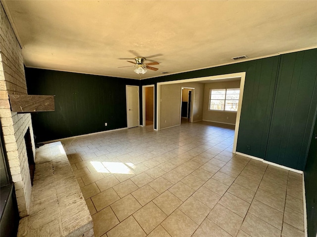 unfurnished living room featuring ceiling fan, a brick fireplace, and light tile patterned floors