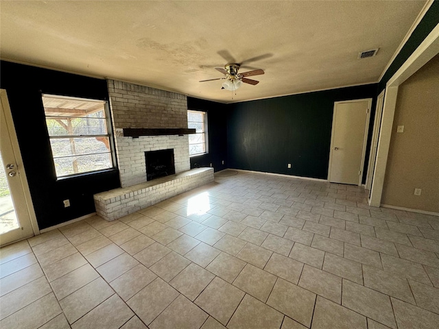 unfurnished living room featuring a brick fireplace, light tile patterned floors, a textured ceiling, and ceiling fan