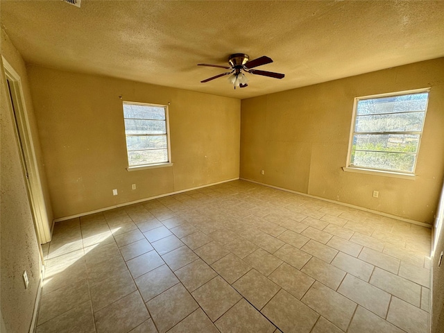 unfurnished room with a textured ceiling, ceiling fan, and light tile patterned flooring