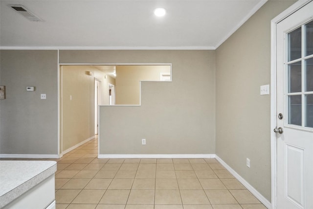 tiled spare room featuring crown molding