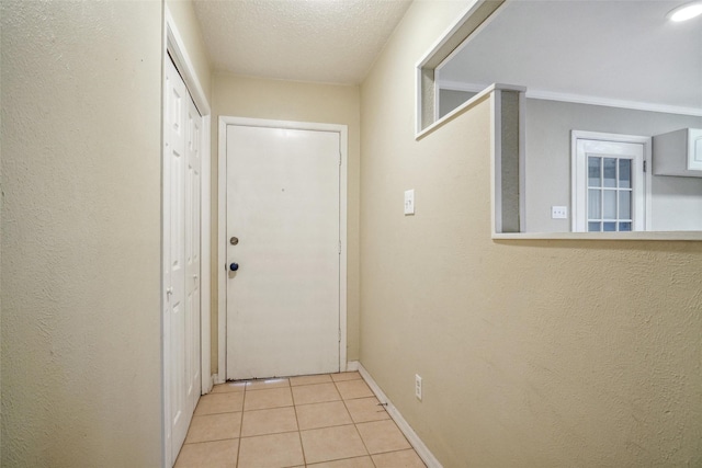 doorway featuring light tile patterned floors and a textured ceiling