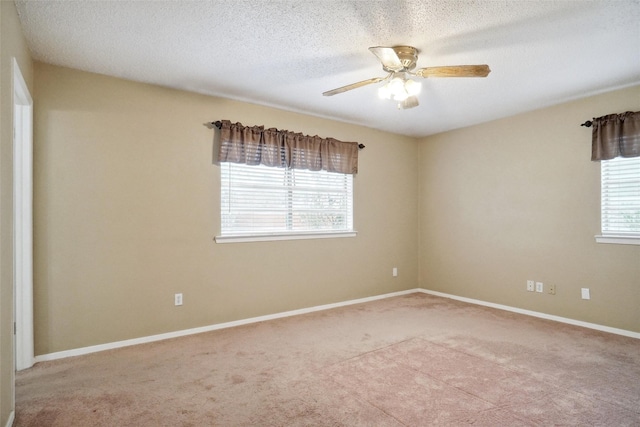 unfurnished room with ceiling fan, a textured ceiling, light colored carpet, and a healthy amount of sunlight