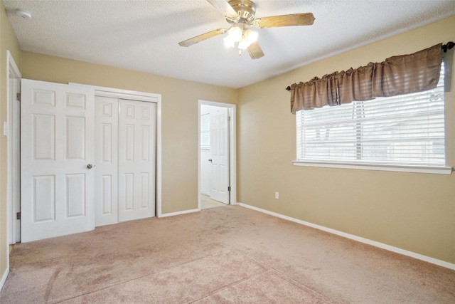 unfurnished bedroom with light carpet, a closet, and a textured ceiling