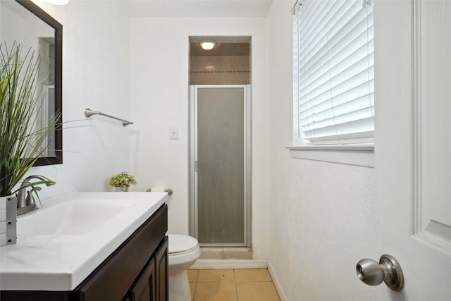 bathroom featuring vanity, toilet, tile patterned floors, and a shower with shower door