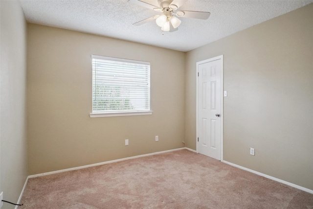 carpeted empty room with ceiling fan and a textured ceiling